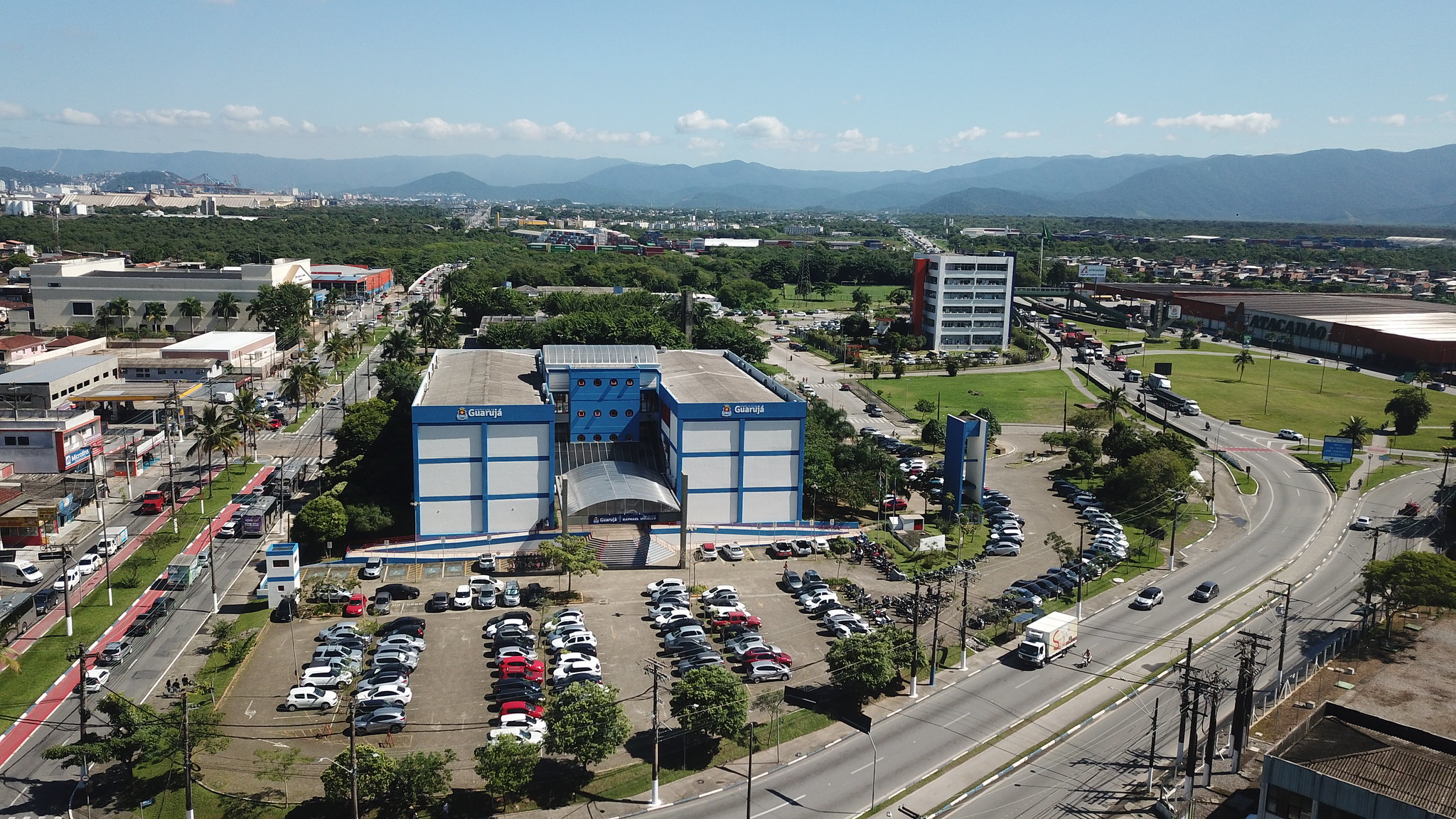 Vista aérea do Paço Municipal Raphael Vitiello, sede da Prefeitura de Guarujá, localizado em Vicente de Carvalho, com avenidas, prédios e áreas verdes ao redor.